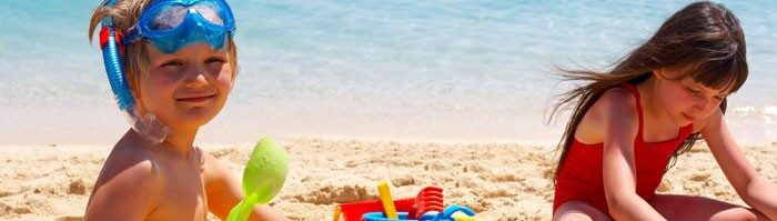 Children playing in the sand next to the sea